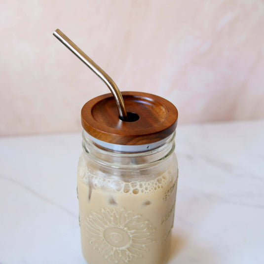 16 oz Sunflower Mason Jar with Acadia wood lid and metal straw filled with iced coffee.